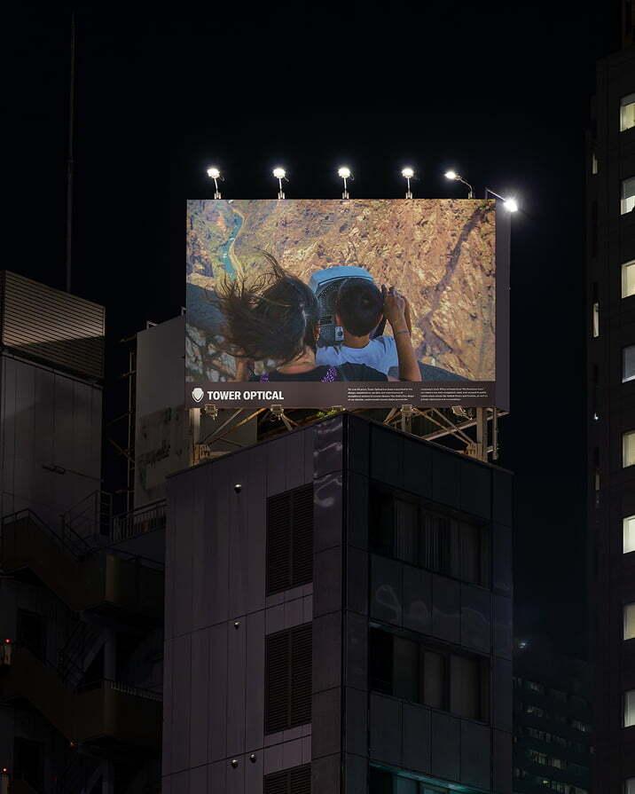 Tower Optical billboard on a city rooftop at night.