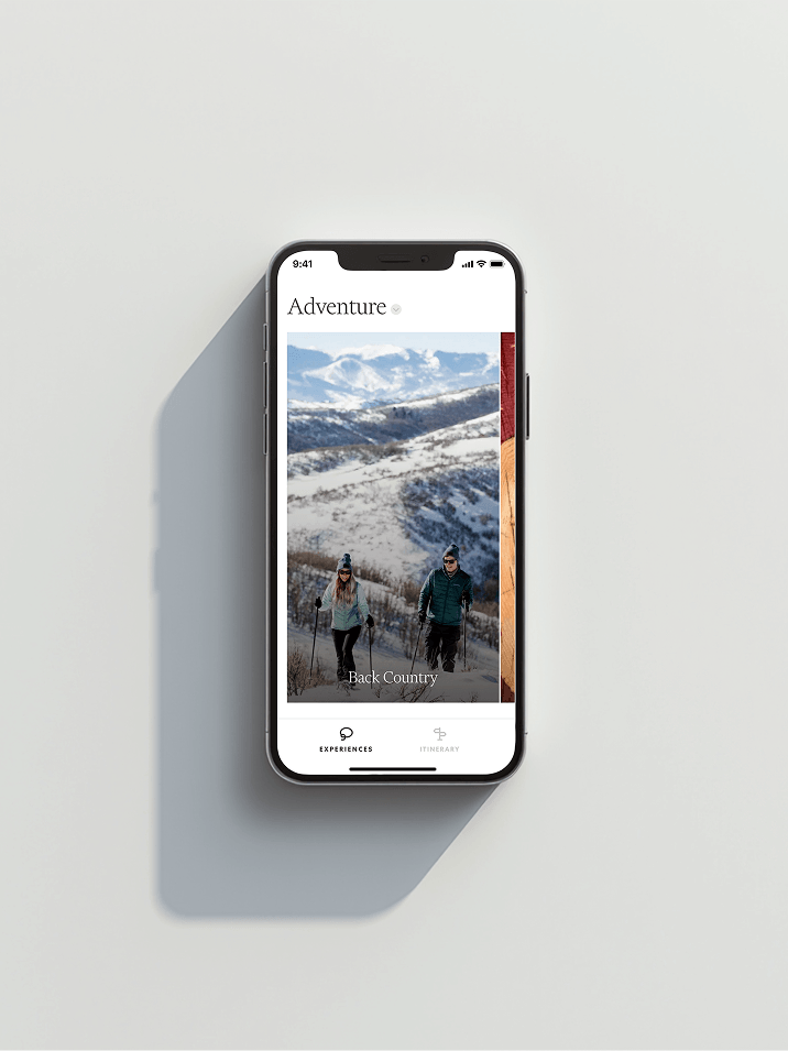 Smartphone showing an Adventure app screen with snowy backcountry scene