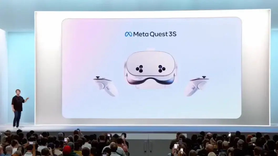 Presenter on stage beside a large Meta Quest 3S headset and controllers slide