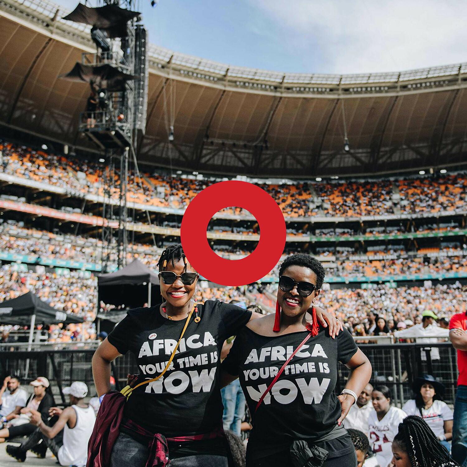 Two women at a stadium with red play button overlay