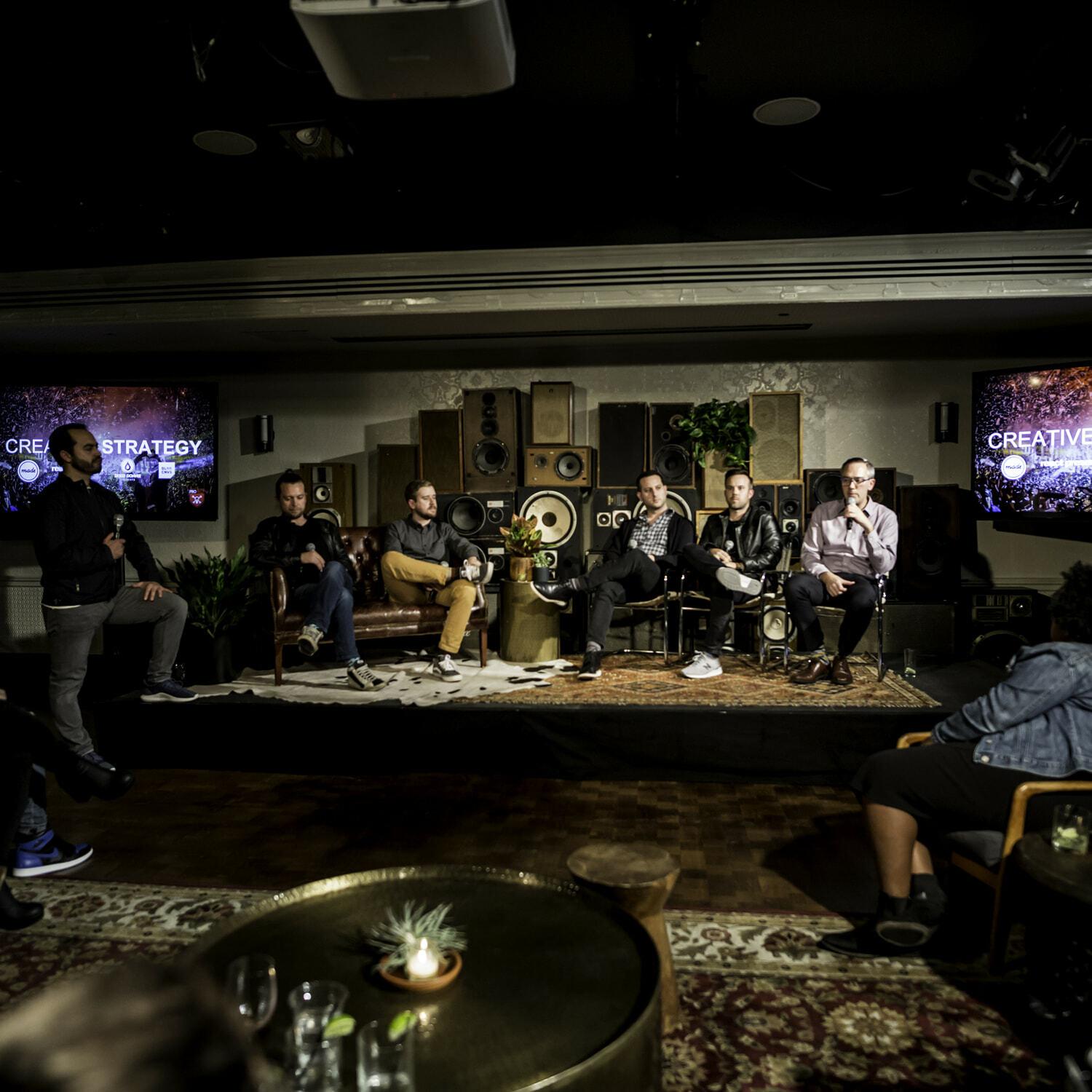 Panel discussion in a lounge-style venue with speakers seated on stage