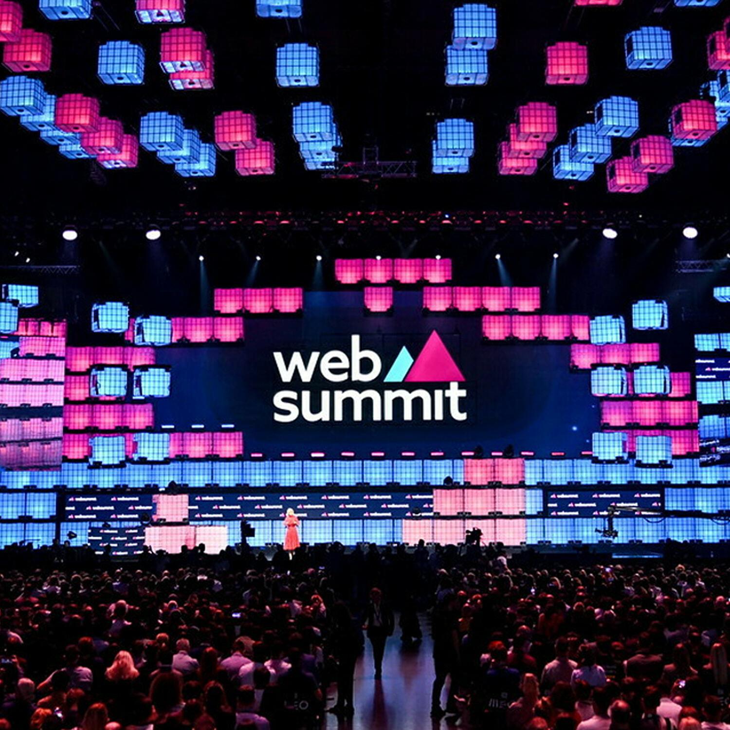 Web Summit stage with colorful cube lights and a large audience