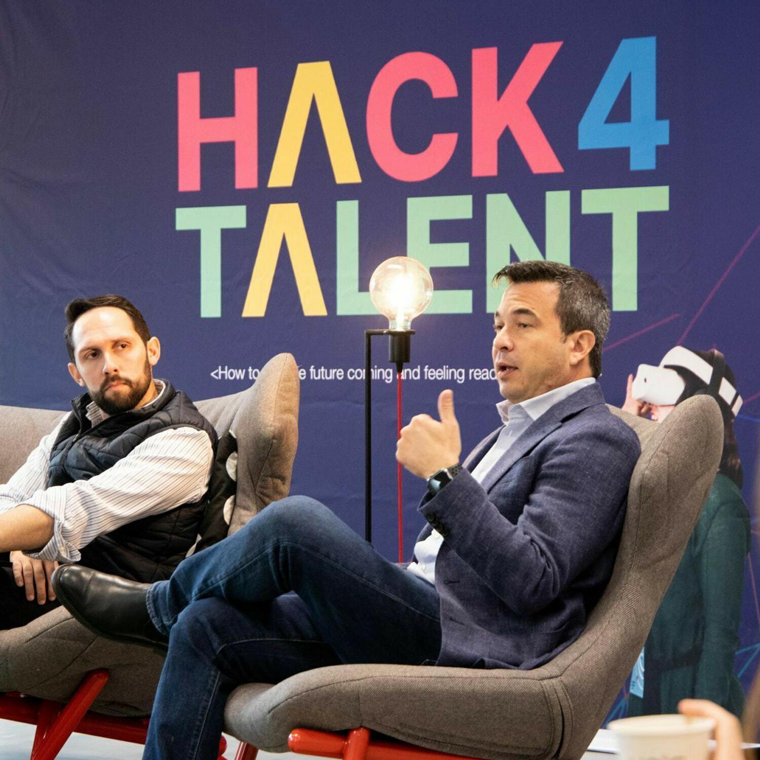 Panel discussion in front of a colorful Hack4Talent backdrop