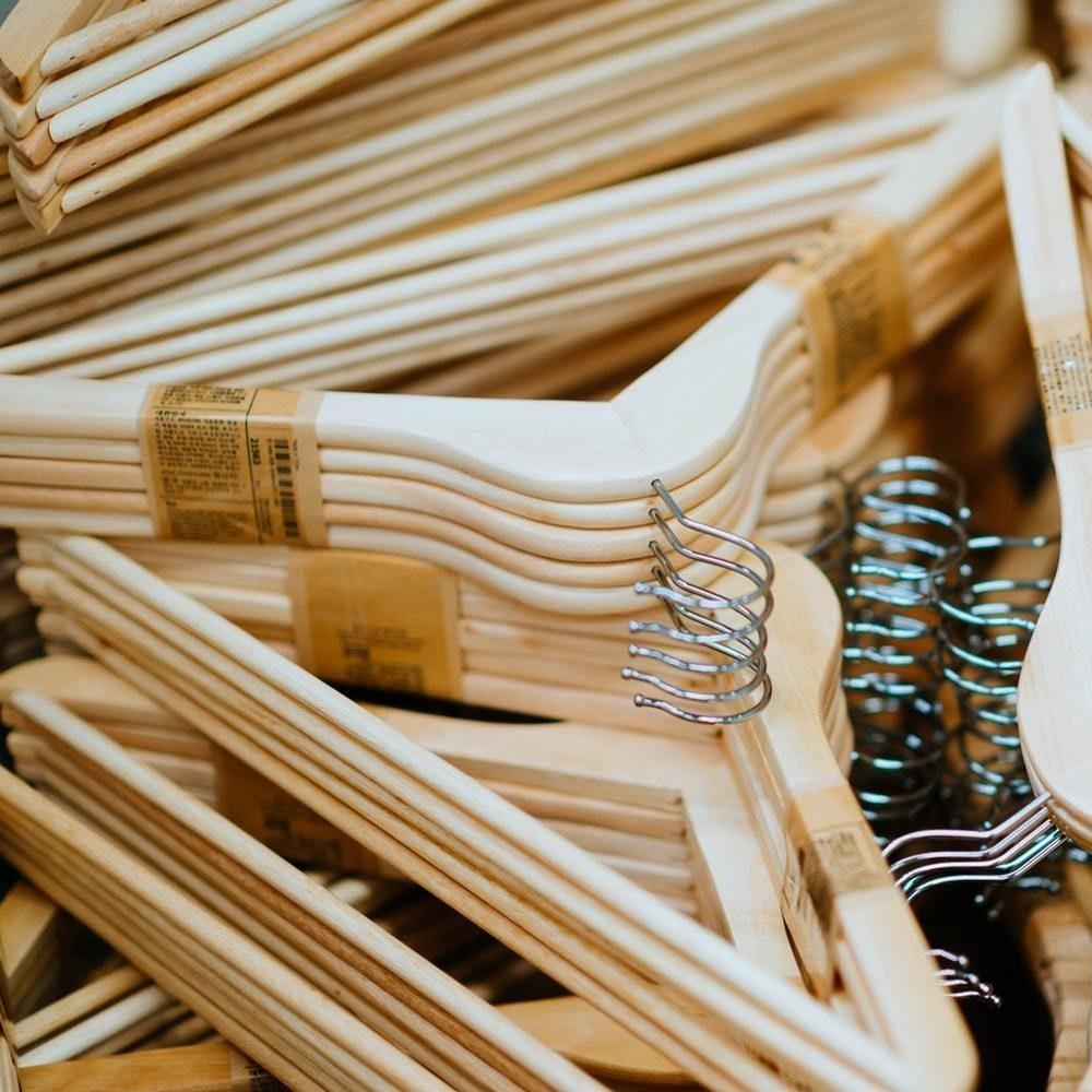 Close-up pile of light wooden clothes hangers with metal hooks