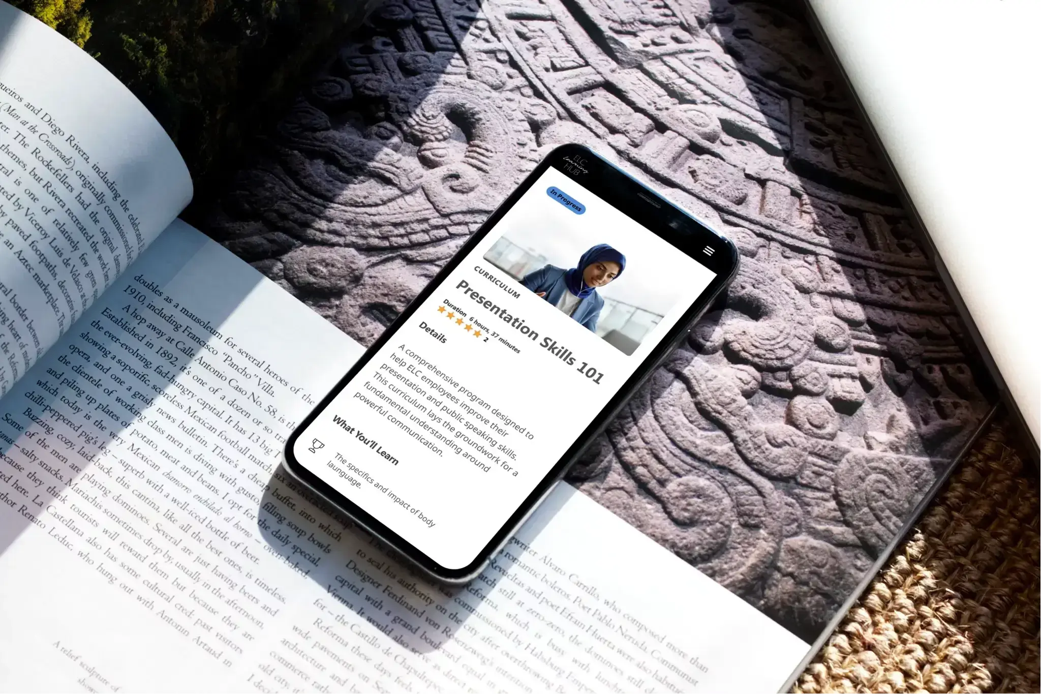 Smartphone showing a Presentation Skills 101 lesson on an open book