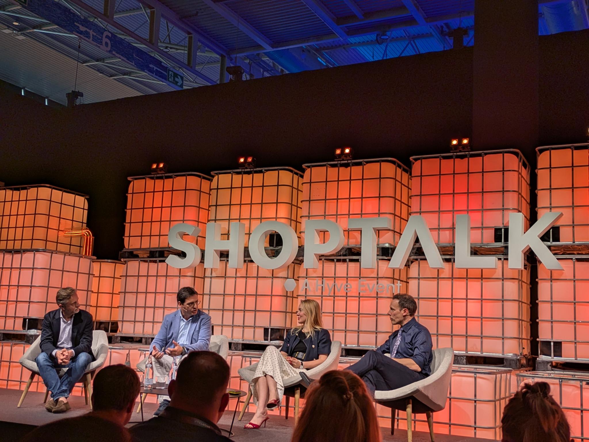 Shoptalk panel discussion on an orange lit stage