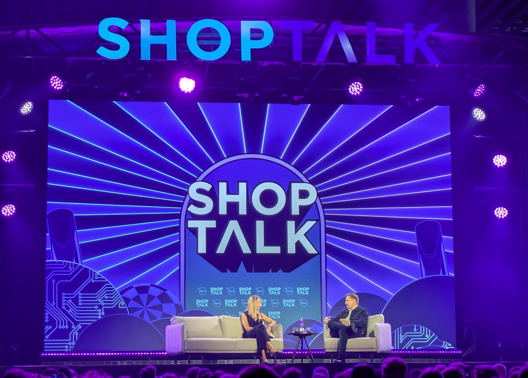 Shoptalk stage with two speakers under blue lighting