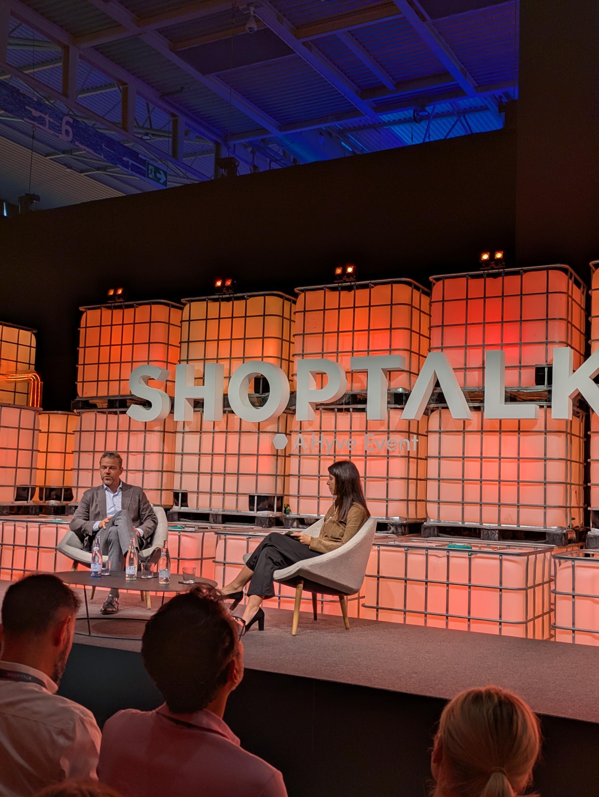 Two speakers seated on a Shoptalk stage