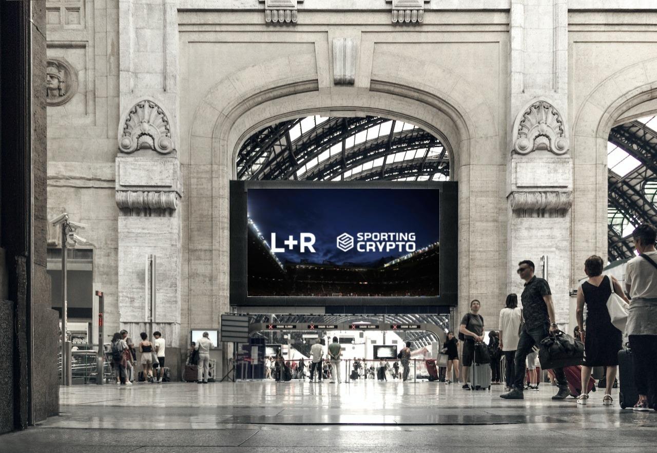 Large L+R and Sporting Crypto billboard inside a train station hall