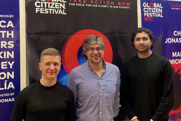 PXL 20230122 035425458 Three people standing in front of Global Citizen Festival posters