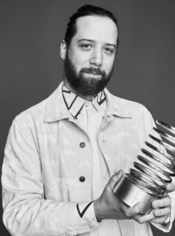Screen Shot 2023 01 26 at 4 15 4 Black-and-white portrait of a bearded man holding a trophy